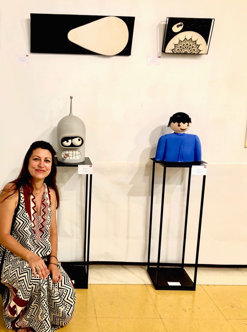 Alumna de Open project posando con sus piezas en una exposición.